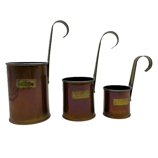 This is a set of Vintage Copper and brass Measuring Cup Ladles. A Set of comprising of  2 Pint 1 Pint 1/2 Pint. Originally used by a pub to measure ale or cider. They are made of copper with brass capacity labels and hooked handles for hanging