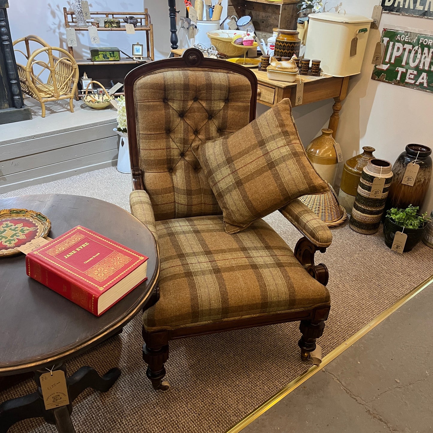 A handsome late Victorian mahogany open armchair, dating from the late 19th century, featuring beautifully carved scroll arms, turned front legs and original brass and ceramic castors.