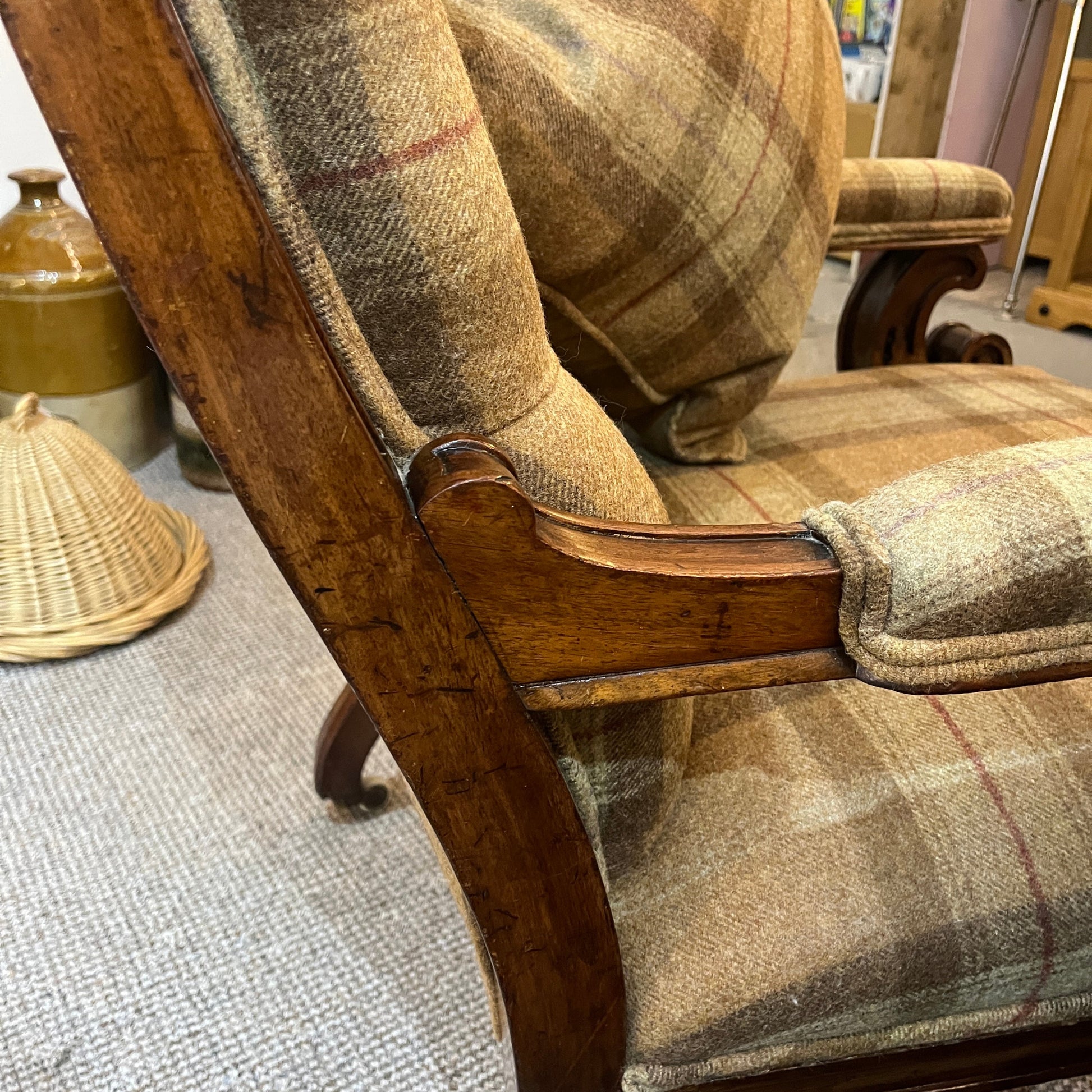A handsome late Victorian mahogany open armchair, dating from the late 19th century, featuring beautifully carved scroll arms, turned front legs and original brass and ceramic castors.