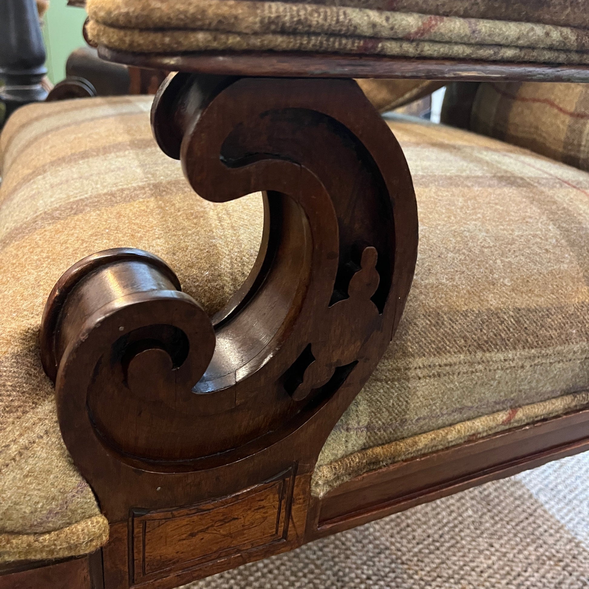 A handsome late Victorian mahogany open armchair, dating from the late 19th century, featuring beautifully carved scroll arms, turned front legs and original brass and ceramic castors.