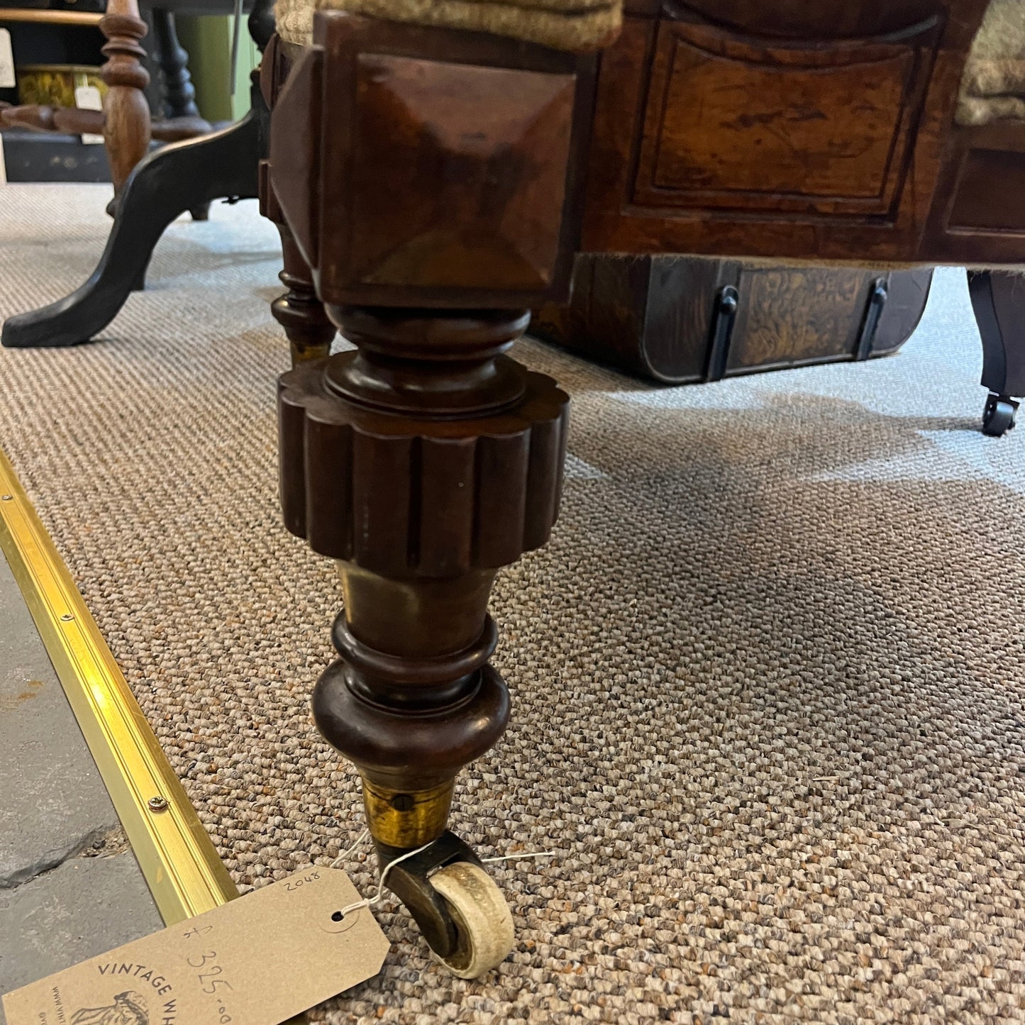 A handsome late Victorian mahogany open armchair, dating from the late 19th century, featuring beautifully carved scroll arms, turned front legs and original brass and ceramic castors.