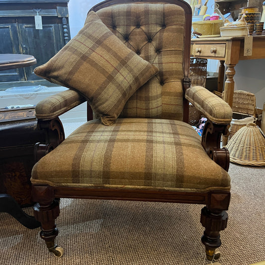 A handsome late Victorian mahogany open armchair, dating from the late 19th century, featuring beautifully carved scroll arms, turned front legs and original brass and ceramic castors.