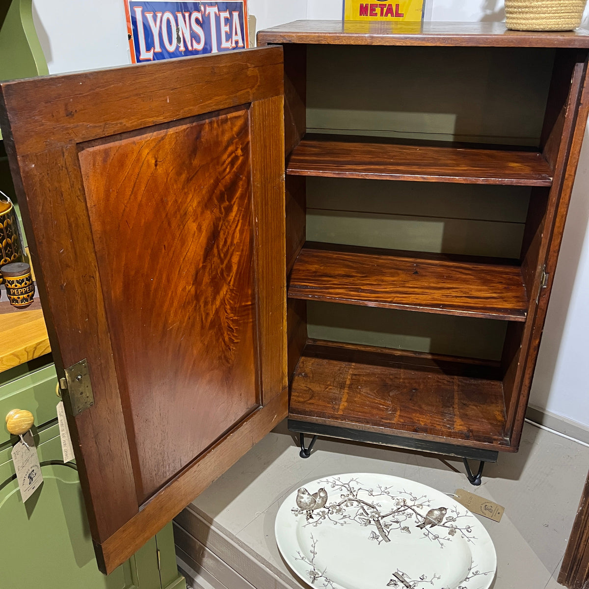 A charming antique mahogany cupboard featuring a beautifully figured flame mahogany panelled door with its original brass escutcheon and rich aged patina.