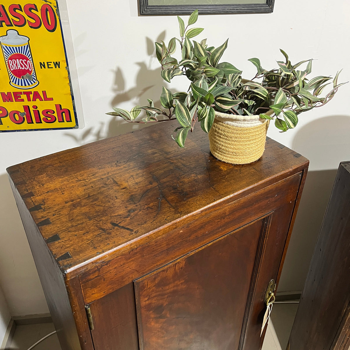 A charming antique mahogany cupboard featuring a beautifully figured flame mahogany panelled door with its original brass escutcheon and rich aged patina.