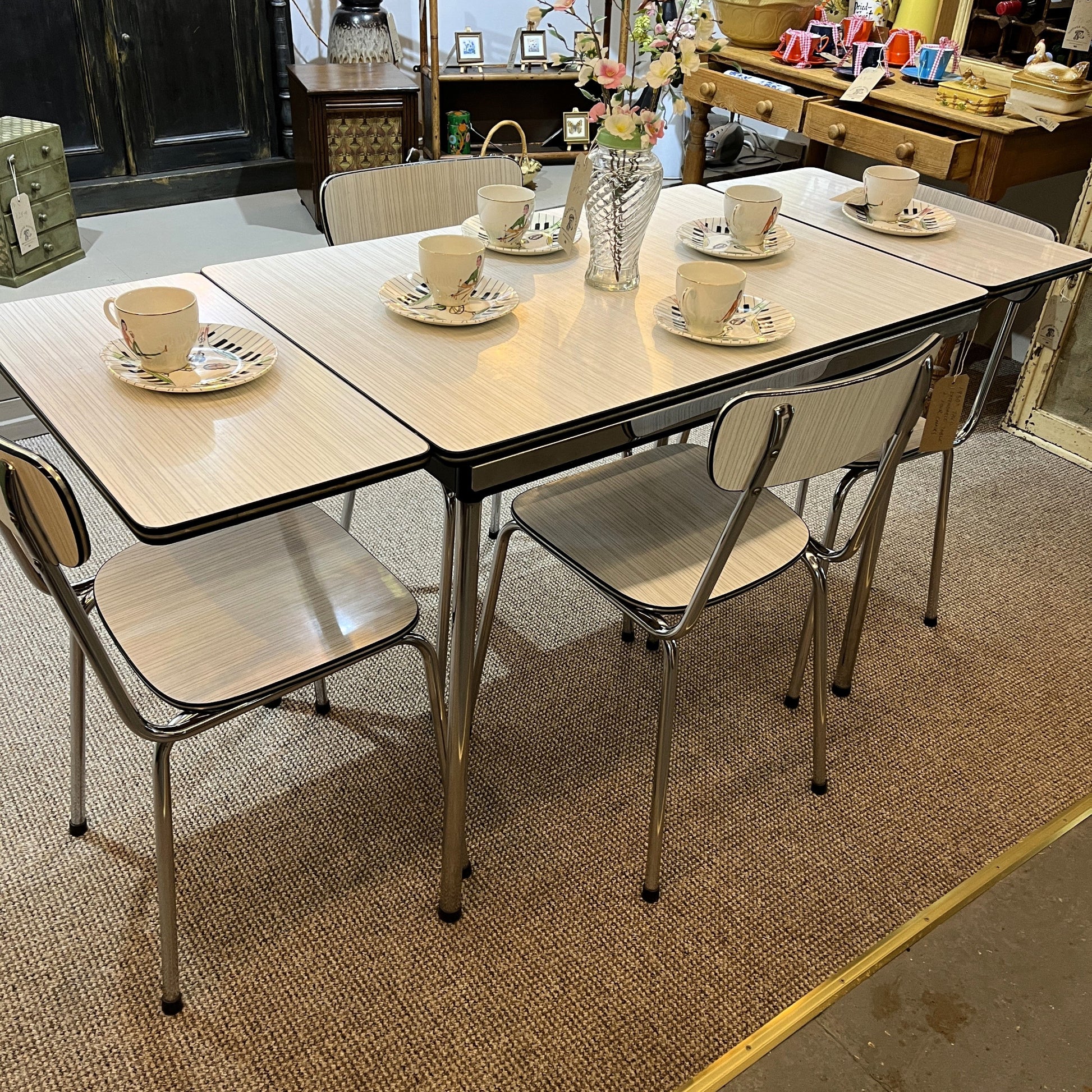 This is a 1950s or 60s Tavos Formica Kitchen Table and chairs. Formica table top, chair seats and backrests supported by very clean chrome metal work.