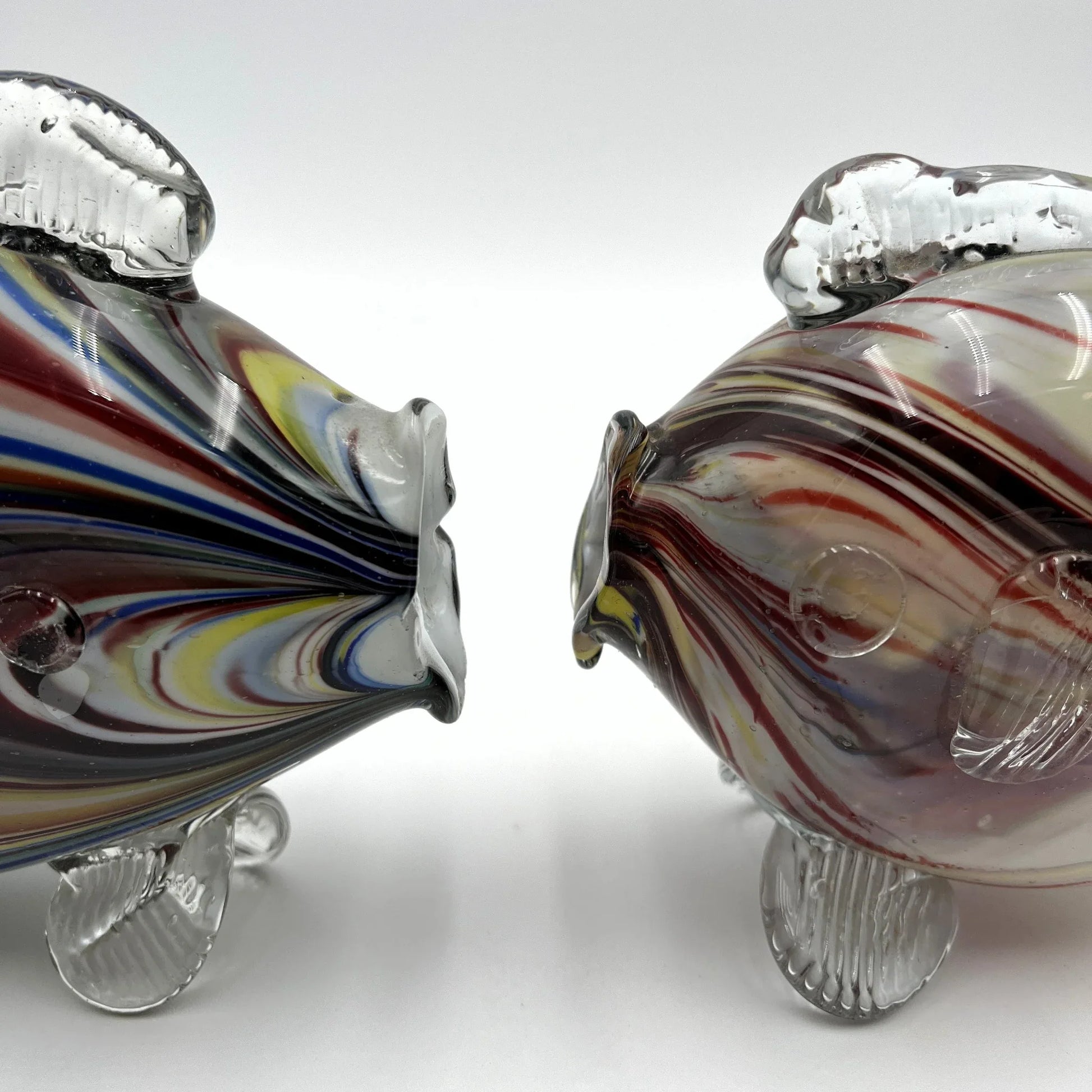 This is a pair of mid-century Spatter, End of Day, or marbled fish. They feature a colourful marbled design with clear glass fins.