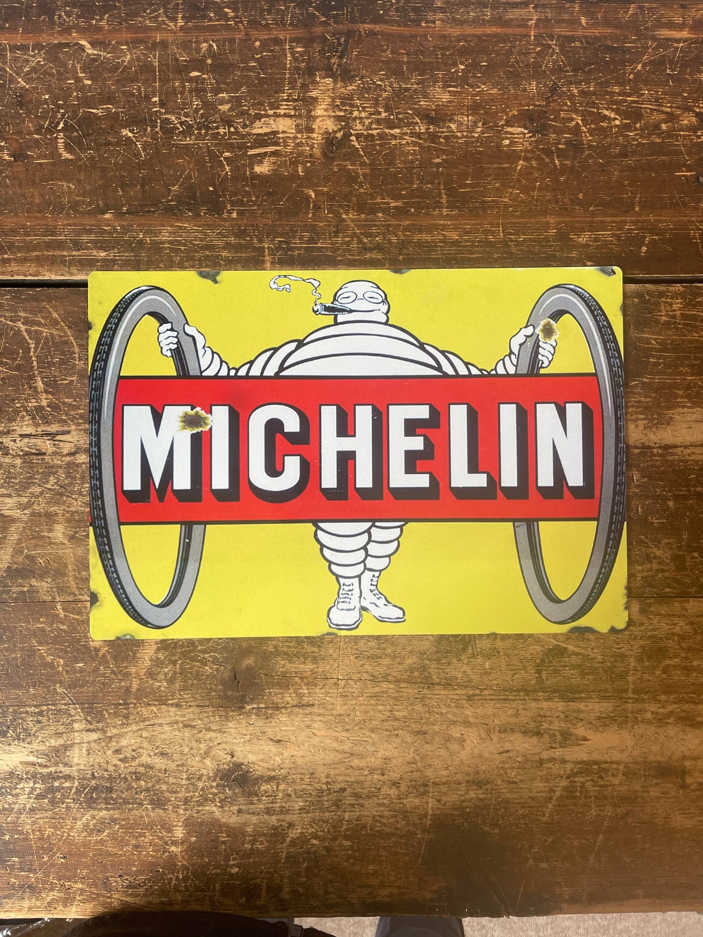 Vintage-Style Michelin man logo Sign  on a wooden background, from Vintage Whippet