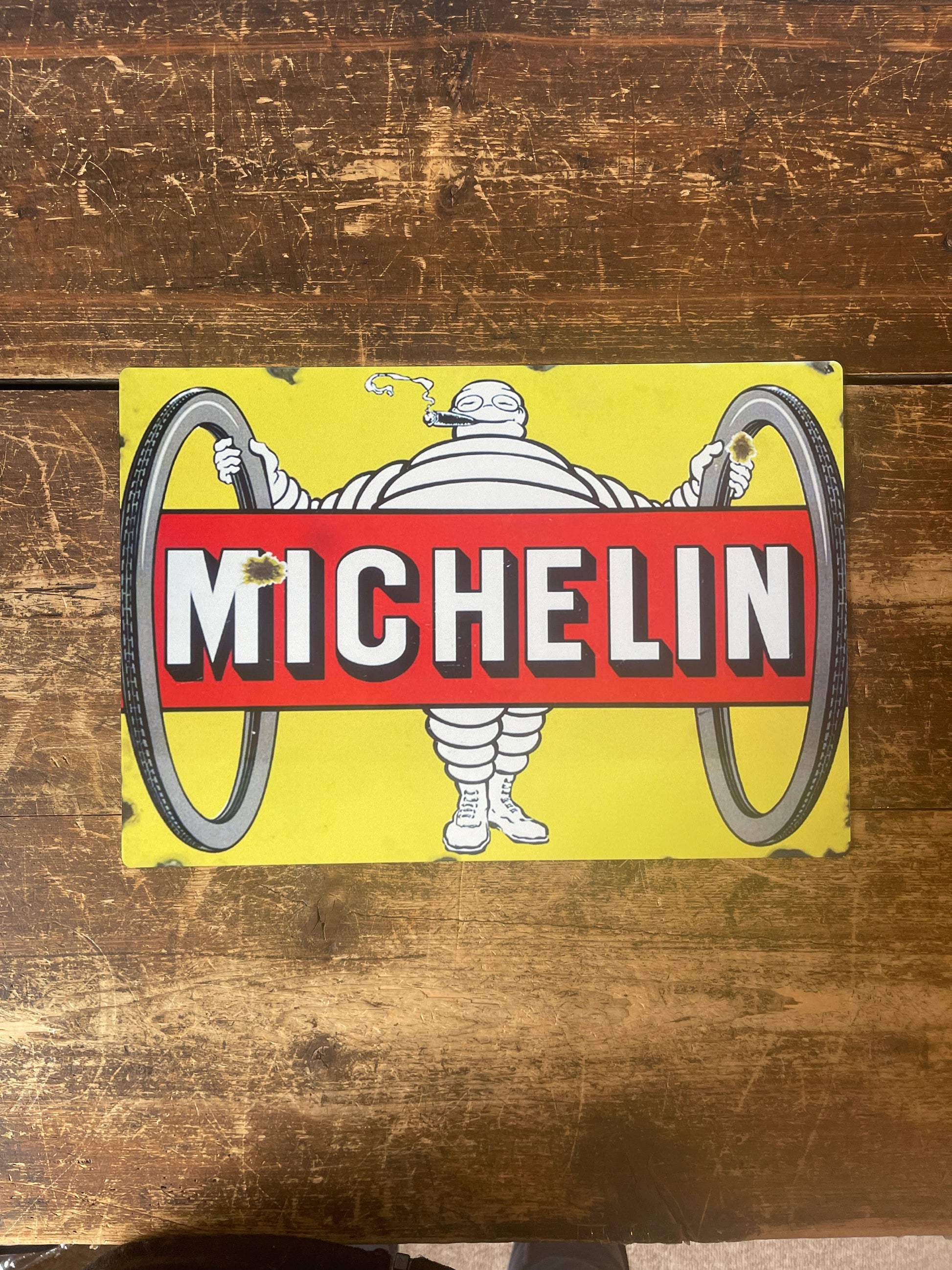 Vintage-Style Michelin man logo Sign  on a wooden background, from Vintage Whippet