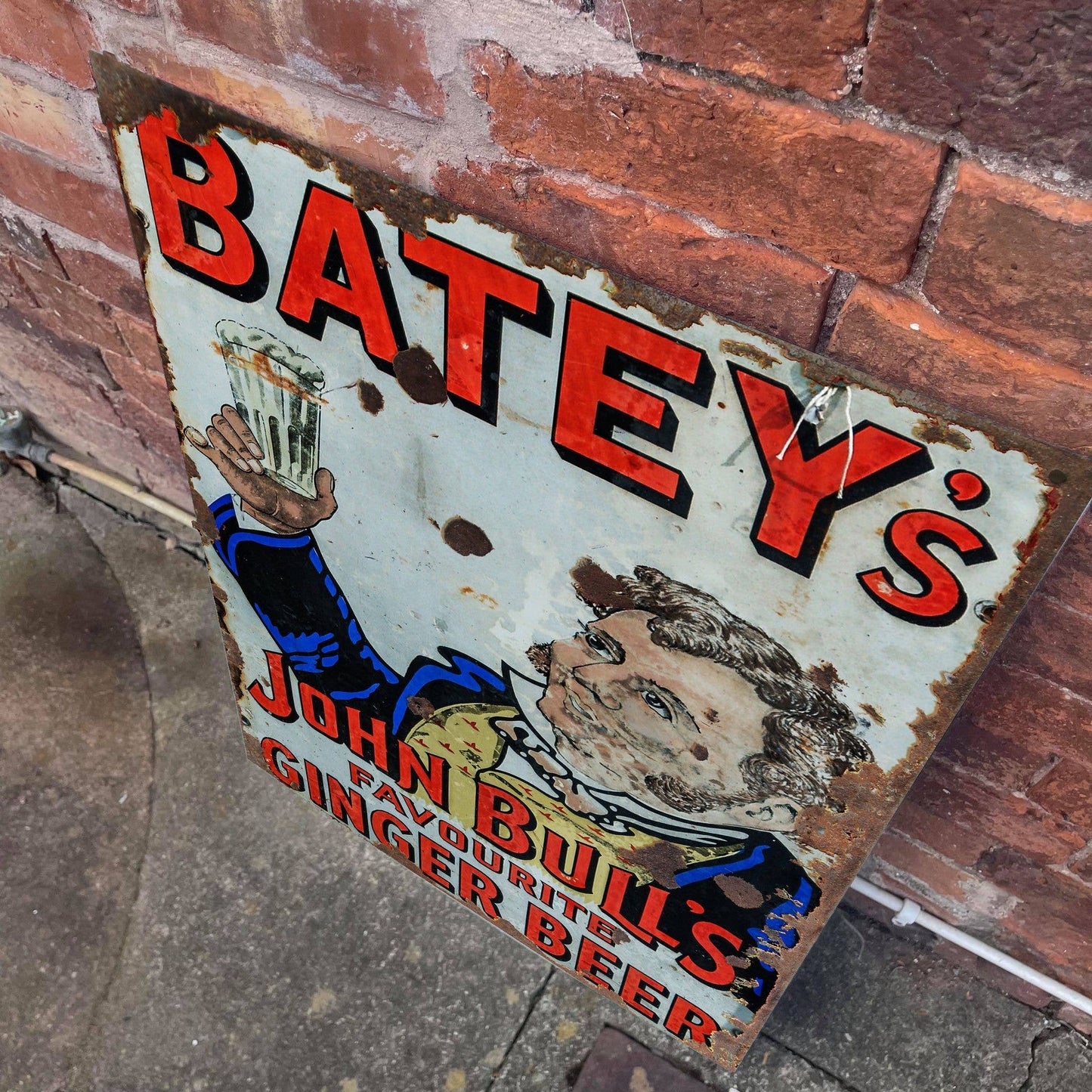 Vintage-style sign for Batey's John Bull's Ginger Beer against a brick wall, from Vintage.Whippet