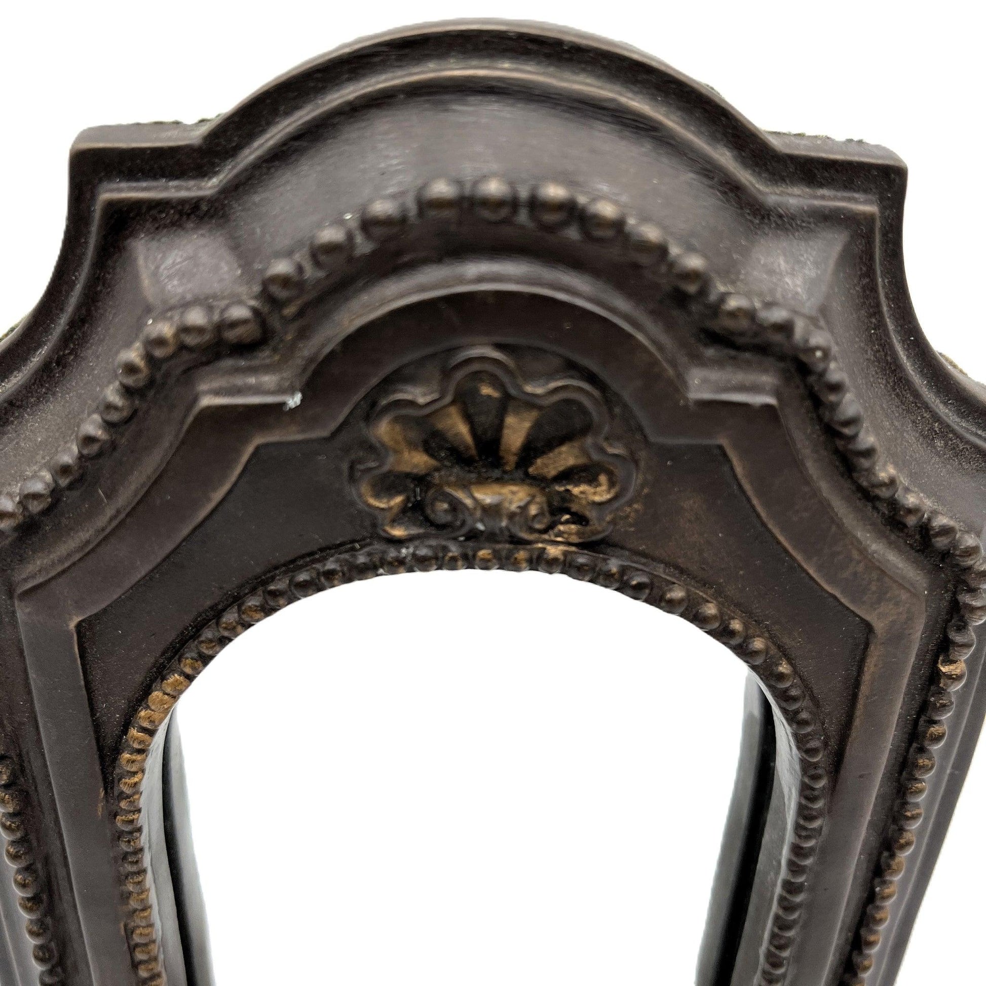 This is a used heavy, vintage-style mirrored wall candle sconce in a bronze-like finish. It has lovely detailing with worn gold accents. It has a felt back with a ring for hanging.