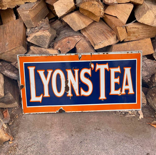 Vintage-style 'Lyons Tea' Sign in front of stacked wooden logs, from Vintage Whippet