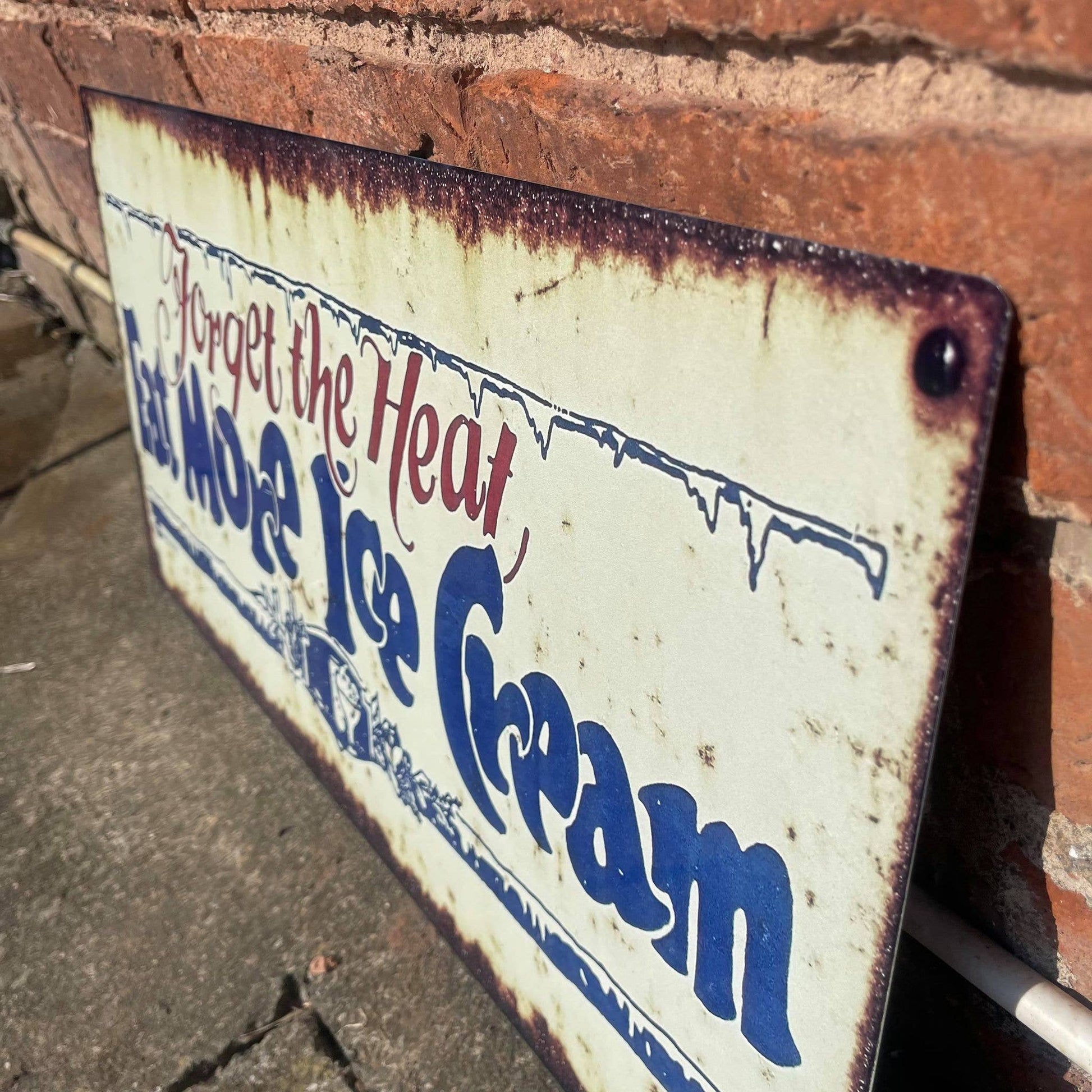 Vintage-style metal sign with text 'Forget the Heat, Eat More Ice Cream' from Vintage Whippet