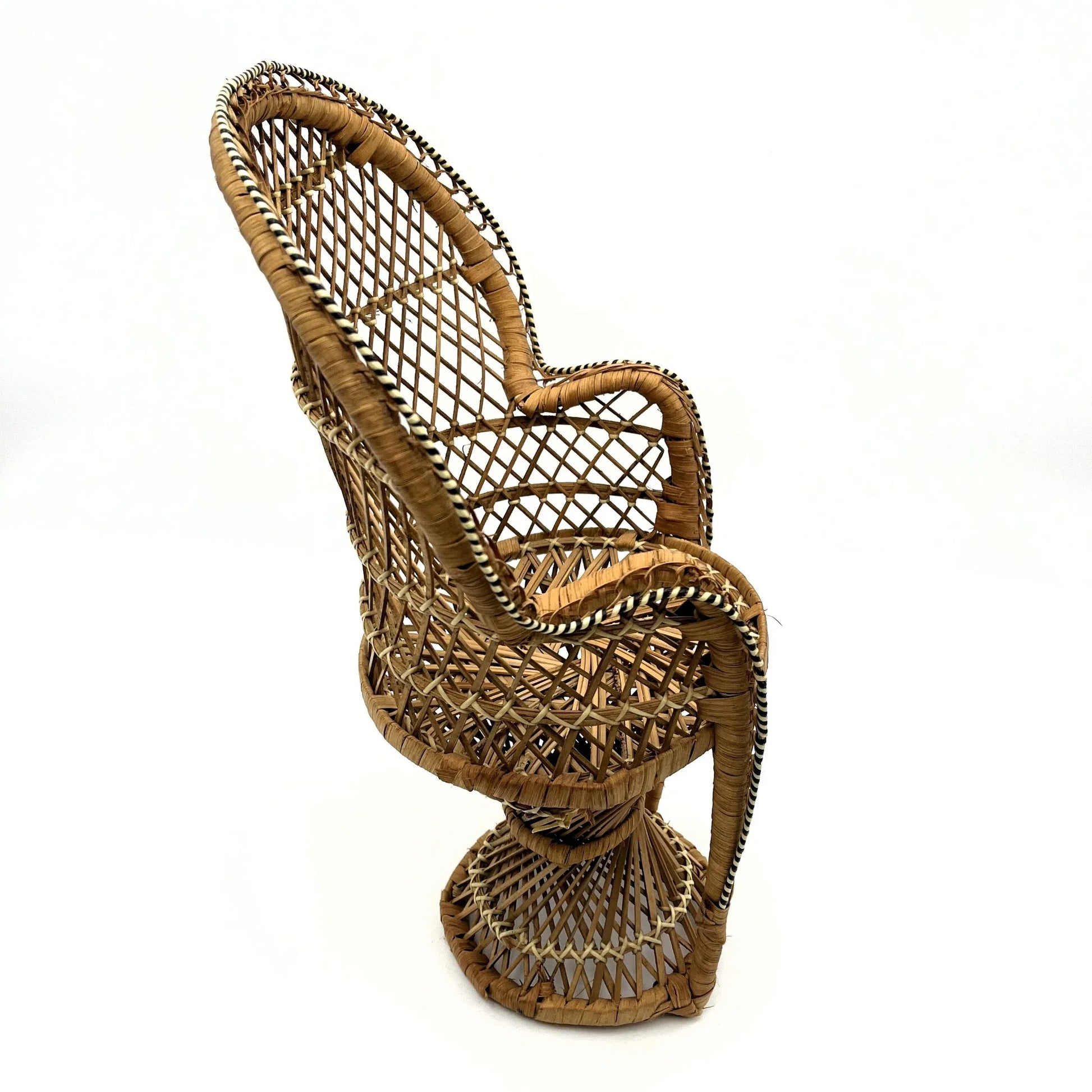 This is a vintage wicker rattan Miniture Peacock Chair with a bohemian pattern. A fun decorative item that can be used to display a plant, teddy or doll.