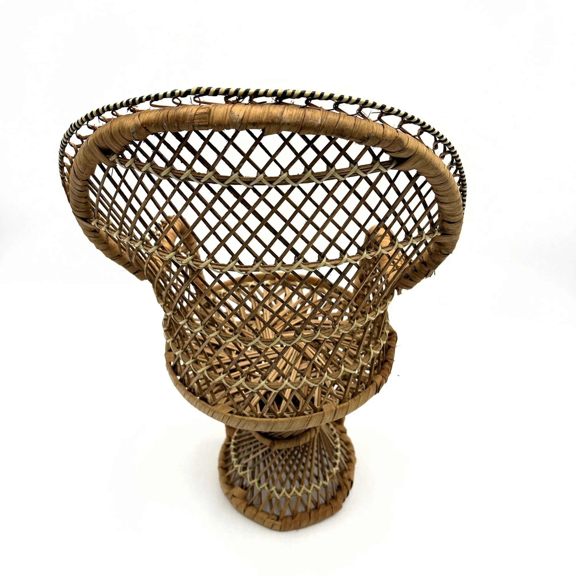 This is a vintage wicker rattan Miniture Peacock Chair with a bohemian pattern. A fun decorative item that can be used to display a plant, teddy or doll.