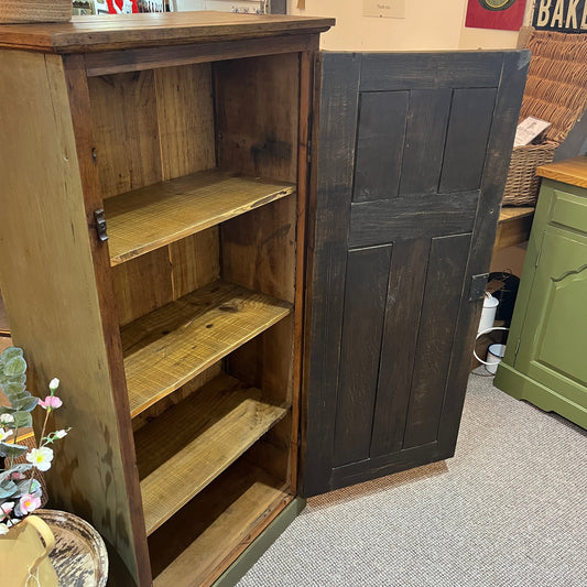 A characterful early 20th-century cupboard featuring a beautifully grained solid oak panelled door complemented by a hand-finished heritage olive-painted carcass