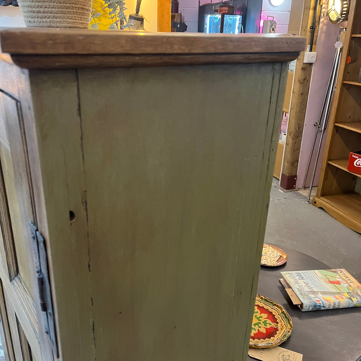 A characterful early 20th-century cupboard featuring a beautifully grained solid oak panelled door complemented by a hand-finished heritage olive-painted carcass