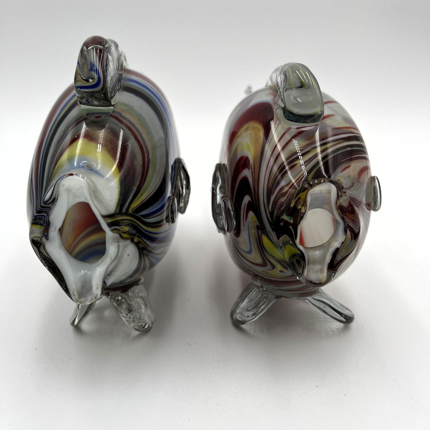 This is a pair of mid-century Spatter, End of Day, or marbled fish. They feature a colourful marbled design with clear glass fins.
