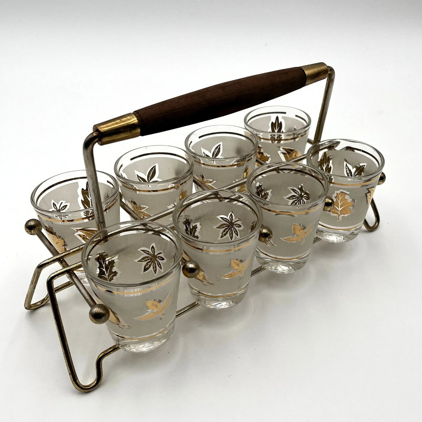 Manufactured in the 1960s, these are a set of 8 vintage Libby frosted gold foil leaf shot glasses, with their own stand.