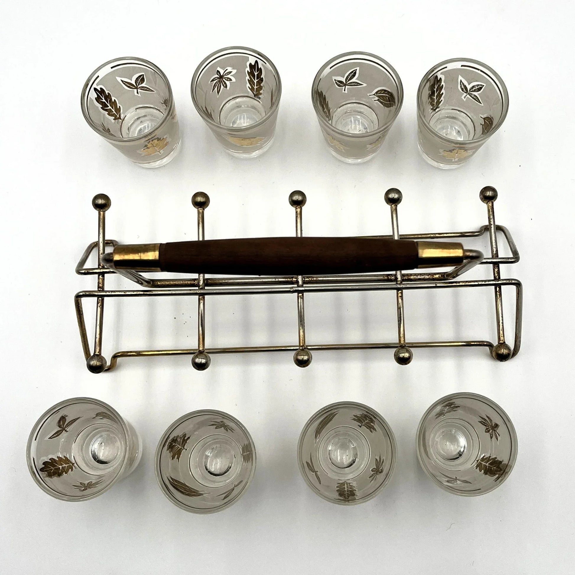 Manufactured in the 1960s, these are a set of 8 vintage Libby frosted gold foil leaf shot glasses, with their own stand.