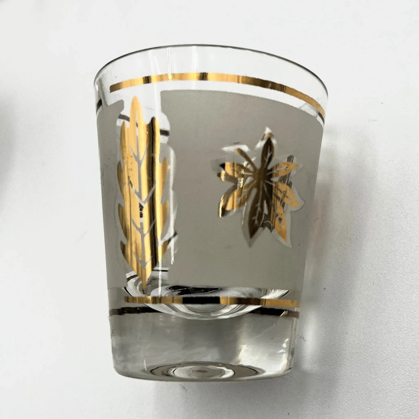 Manufactured in the 1960s, these are a set of 8 vintage Libby frosted gold foil leaf shot glasses, with their own stand.