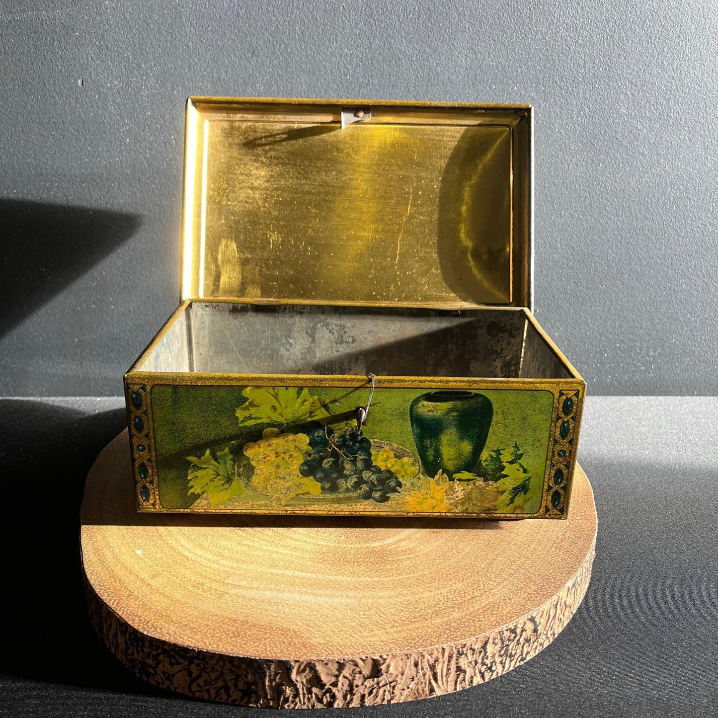 This antique fruit litho art hinged and footed Swiss sweet tin is a rare find for collectors of vintage tins and memorabilia. 