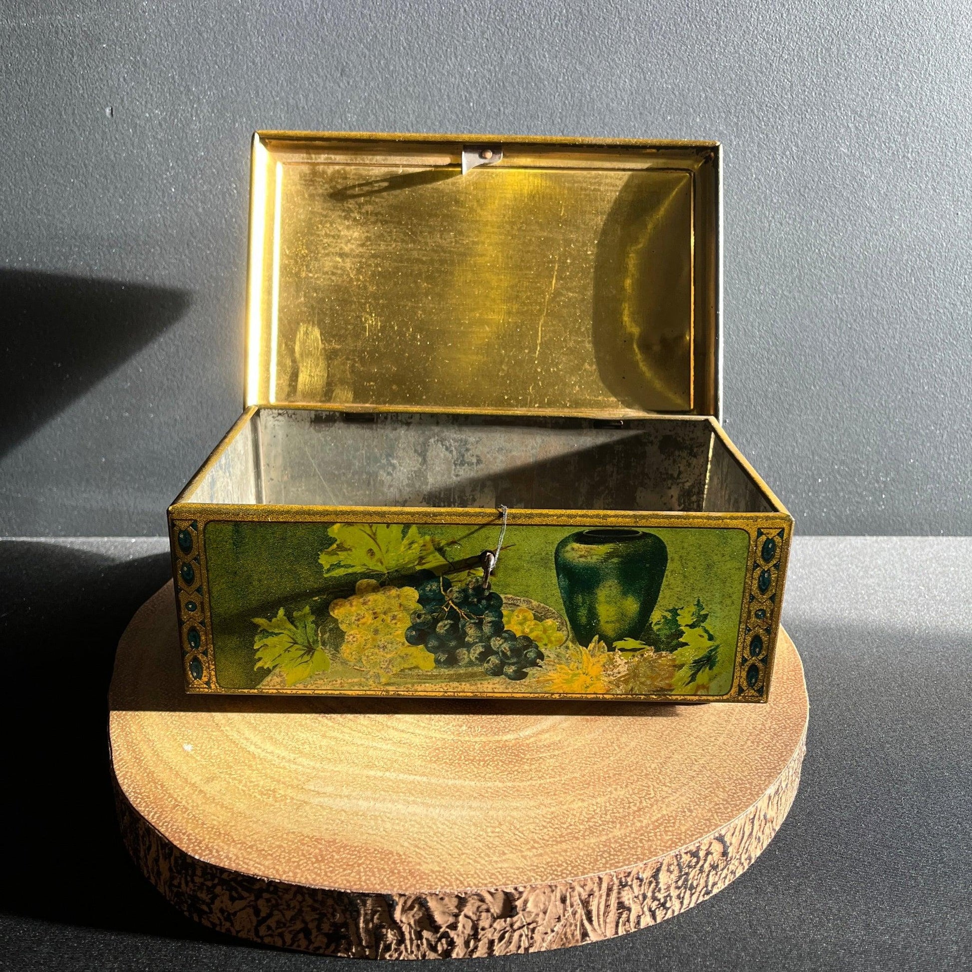 This antique fruit litho art hinged and footed Swiss sweet tin is a rare find for collectors of vintage tins and memorabilia. 